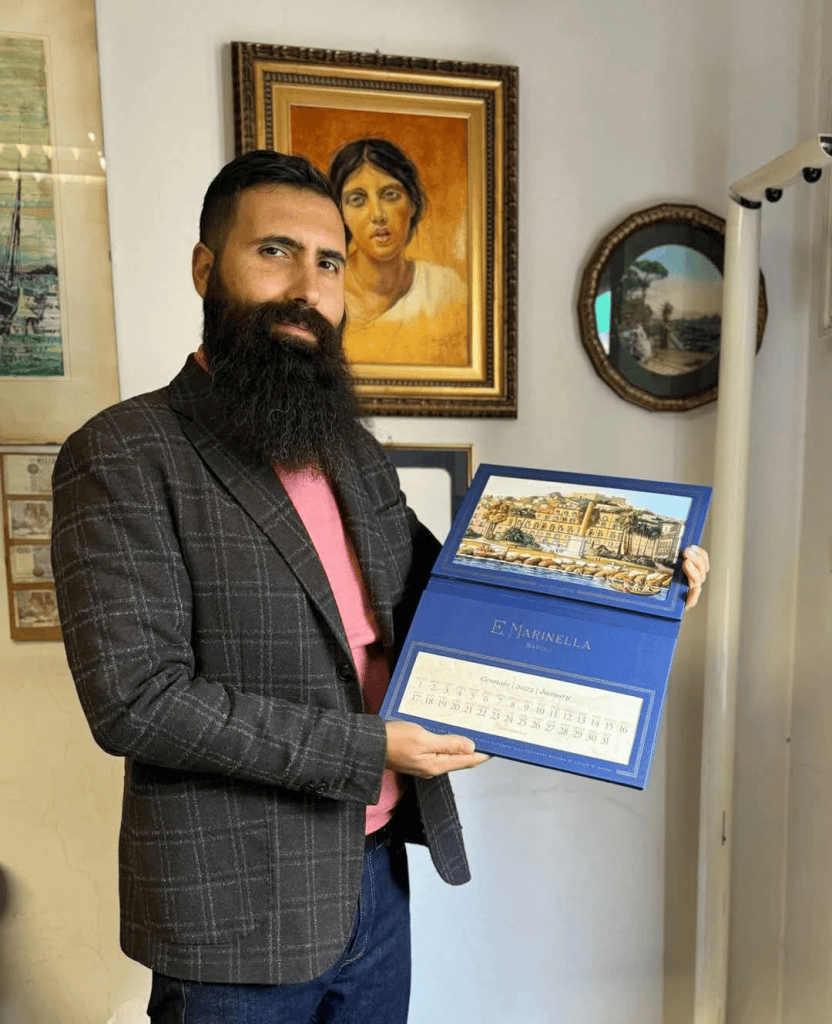 Ruggero M. Savarese mostra il calendario E. Marinella 2025, illustrato con una gouache del lungomare di Napoli